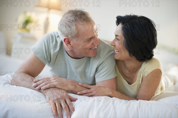 Happy mature couple laying in bed.