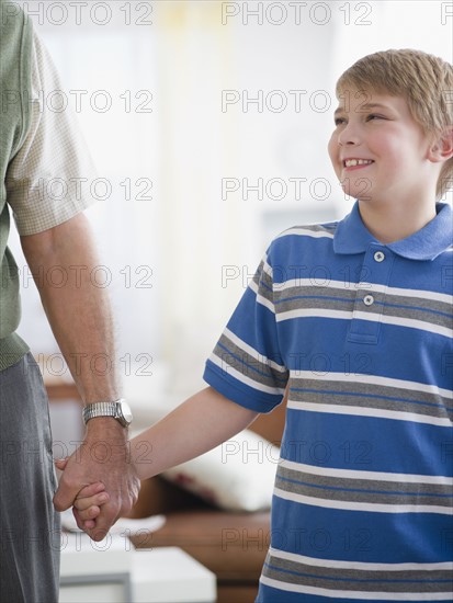 Grandfather and grandson (8-9) holding hands. Photo : Jamie Grill Photography
