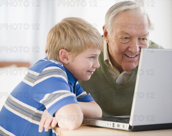 Grandfather and grandson (8-9) using laptop. Photo : Jamie Grill Photography