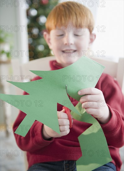 Boy (8-9) making Christmas tree decoration. Photo : Jamie Grill Photography