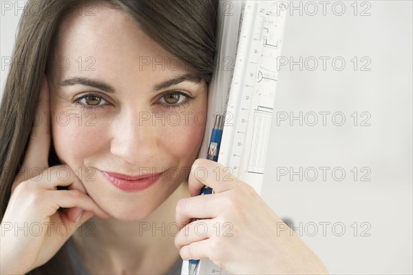 Close-up of woman holding ruler and pencil.