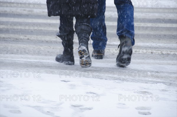 USA, New York City, Pedestrians crossing road in blizzard.