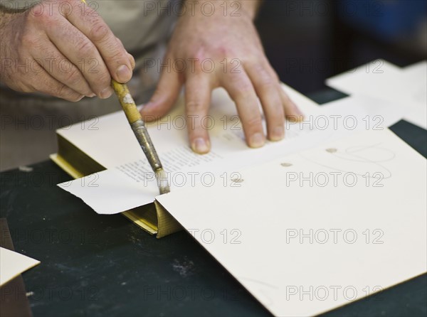 Craftsman making book bindings.