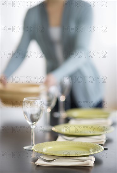 Young woman setting table.