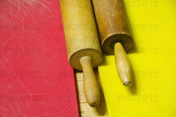 Two rolling pins on chopping boards.