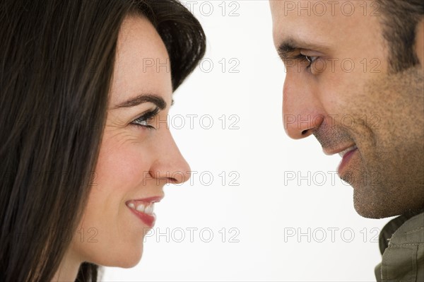 Studio profile of couple looking in eyes face to face.