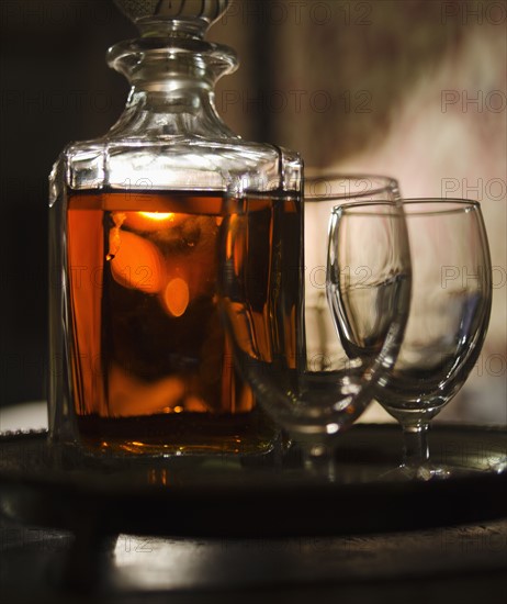 Whiskey in decanter with glasses.