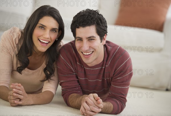 Portrait of couple lying on floor.