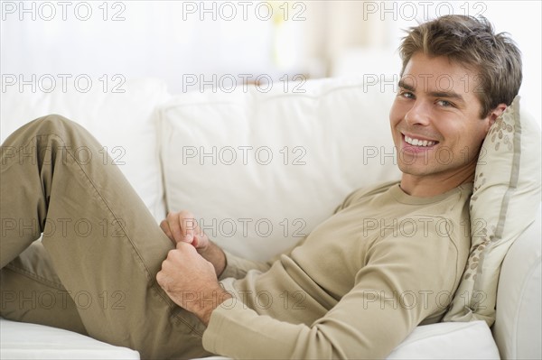 Man sitting on sofa with digital tablet.