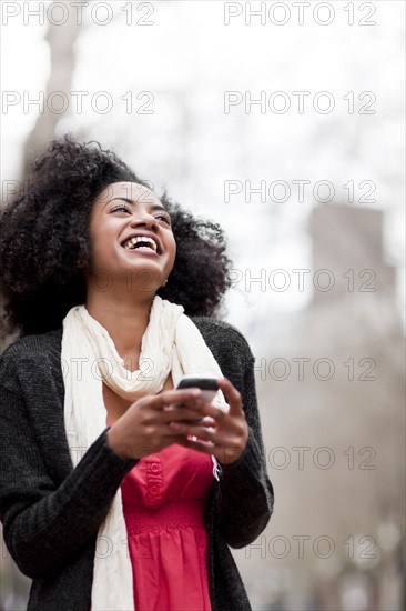 USA, Washington State, Seattle, Cheerful young woman text messaging. Photo : Take A Pix Media