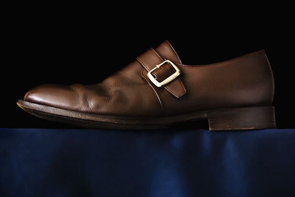 Traditional Buckle shoe on black background. Photo : Joe Clark