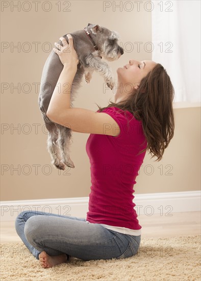 Young woman playing with schnauzer. Photo : Mike Kemp