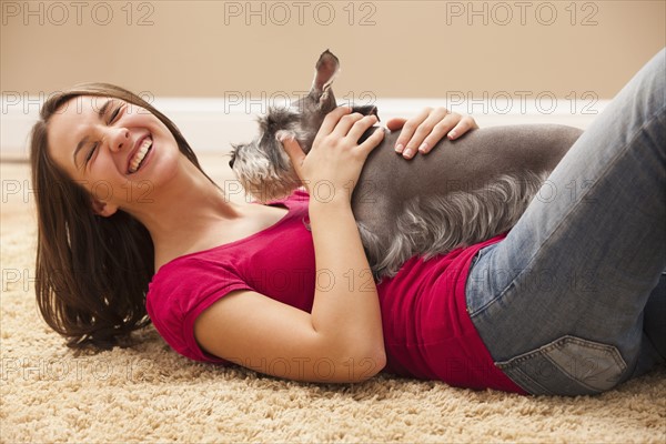 Young woman playing with schnauzer. Photo : Mike Kemp