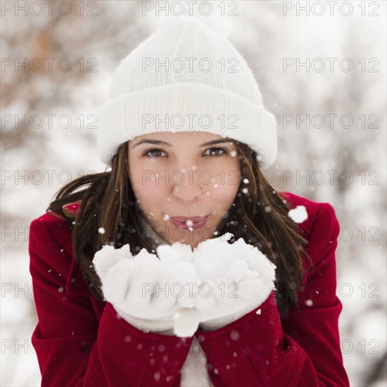 USA, Utah, Lehi, Portrait of young woman blowing snow. Photo : Mike Kemp
