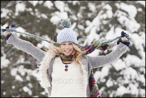 USA, Utah, Salt Lake City, portrait of young woman in winter clothing pulling hat strings. Photo : Mike Kemp