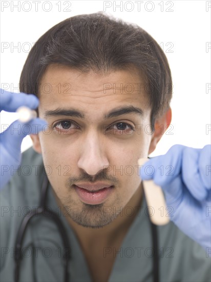 Young surgeon holding small torch in one hand and wooden stick in another. Photo : Dan Bannister