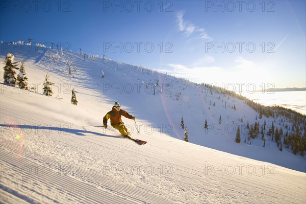 USA, Montana, Whitefish, Male skier on mountain slope at sunrise. Photo : Noah Clayton
