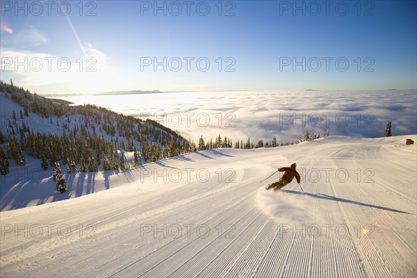 USA, Montana, Whitefish, Male skier on mountain slope at sunrise. Photo : Noah Clayton