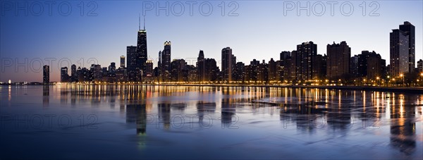 USA, Illinois, Chicago, City skyline over Lake Michigan at sunset. Photo : Henryk Sadura