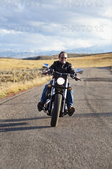 USA, Colorado, Carbondale, Mature man driving motorcycle. Photo : Noah Clayton