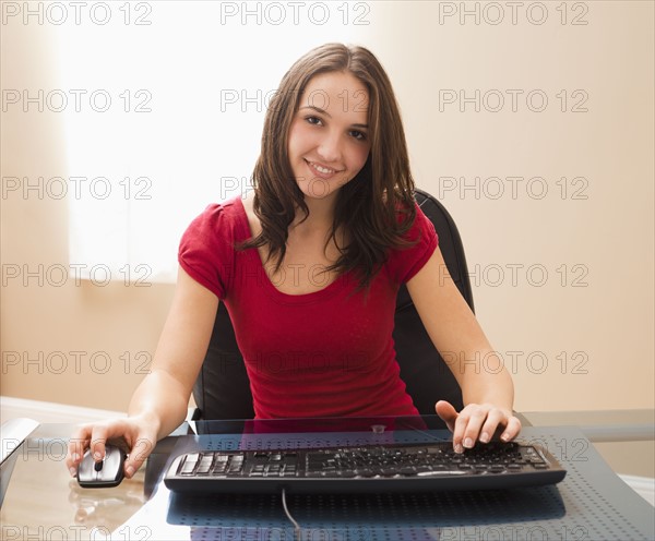 Young woman working on computer. Photo : Mike Kemp