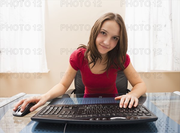 Young woman working on computer. Photo : Mike Kemp