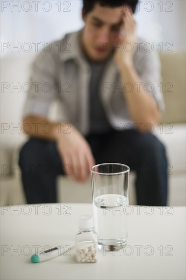 Out-of-focus man taking painkillers.