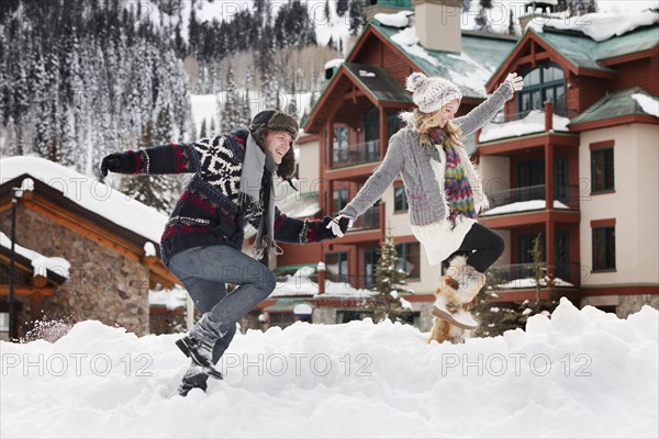 USA, Utah, Salt Lake City, couple walking through snow in resort. Photo : Mike Kemp