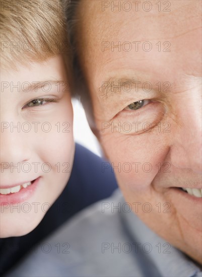 Close up of smiling faces of grandfather and grandson (8-9) . Photo : Jamie Grill Photography