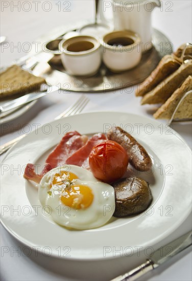 Plate with English breakfast on table.