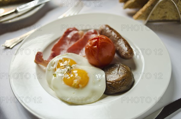 Plate with English breakfast on table.