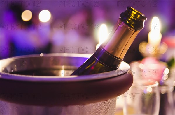 Champagne bottle cooling in ice bucket.