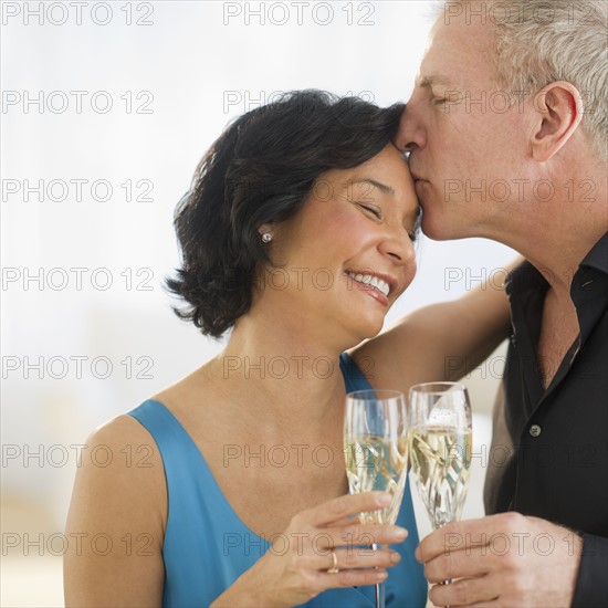 Happy mature couple with flutes.