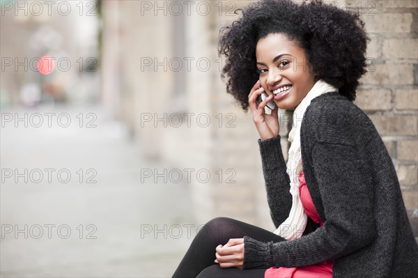 USA, Washington State, Seattle, Cheerful young woman using mobile phone. Photo : Take A Pix Media