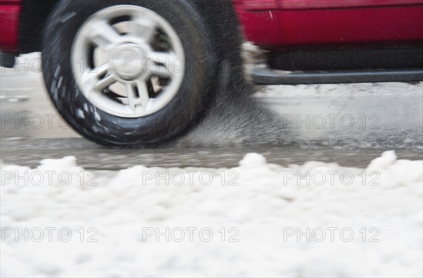 USA, New York, New York City, close up of car's wheels on road in winter.