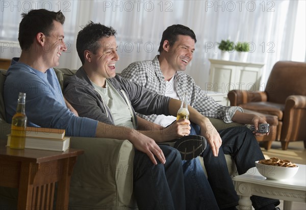 Three men watching television.
