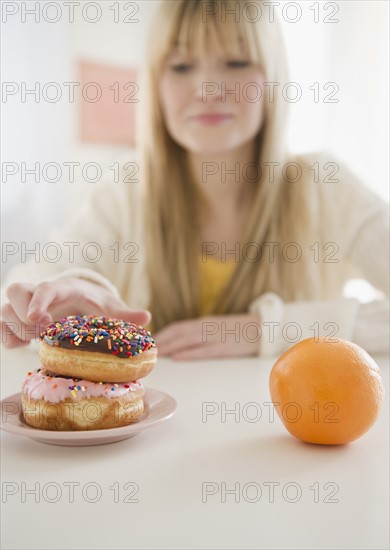 Woman reaching for donut. Photo : Jamie Grill Photography
