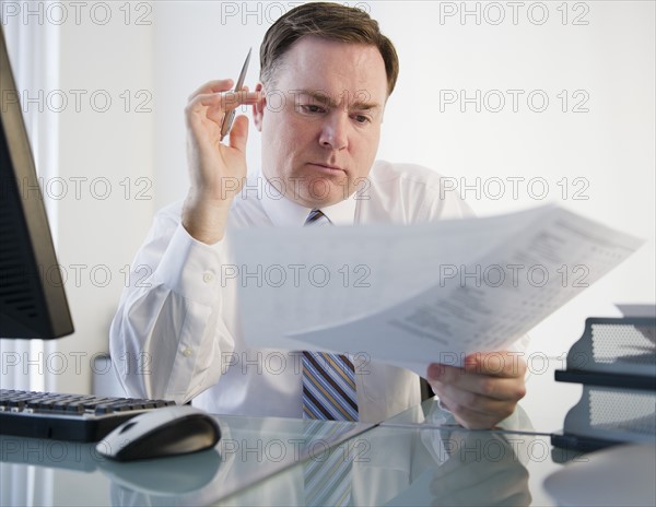 Businessman reading document. Photo: Jamie Grill Photography