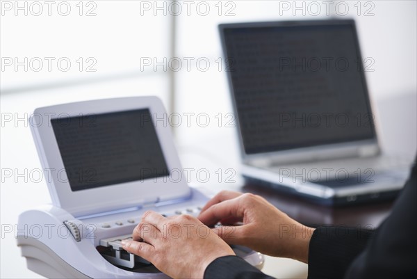 Court stenographer using stenograph machine. Photo : Daniel Grill