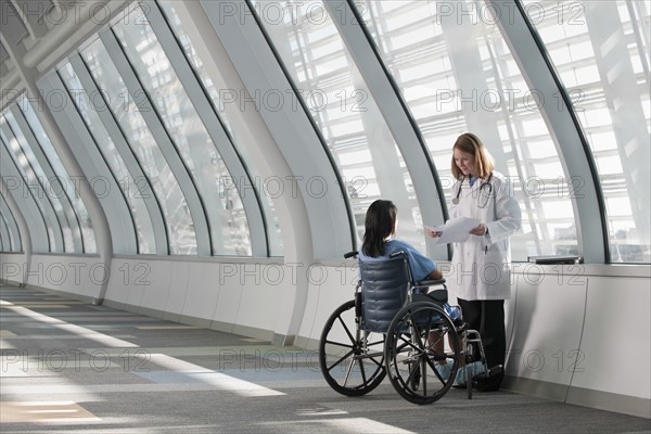 Doctor talking to patient in wheelchair. Photo: Mark Edward Atkinson