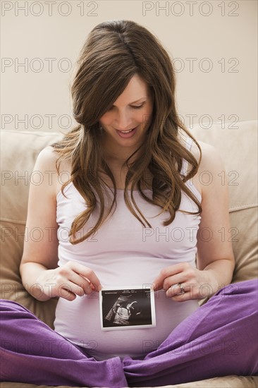 Young pregnant woman looking at CT image of unborn baby. Photo: Mike Kemp