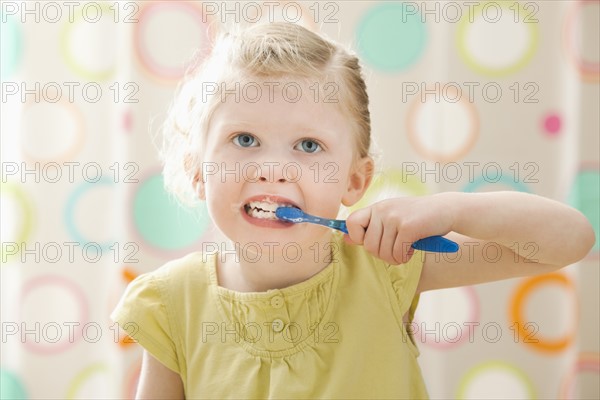 Girl (2-3) brushing teeth. Photo : Mike Kemp