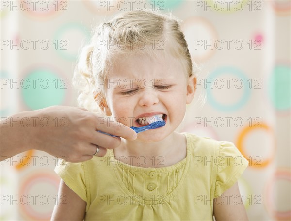 Girl (2-3) having teeth brushed. Photo : Mike Kemp