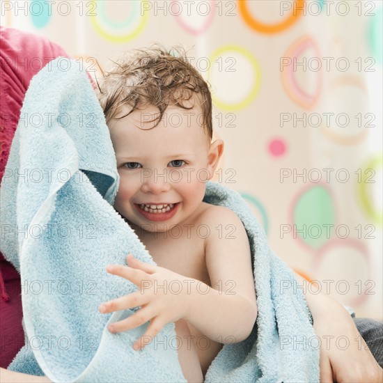 Mother with son (2-3) wrapped in towel. Photo: Mike Kemp