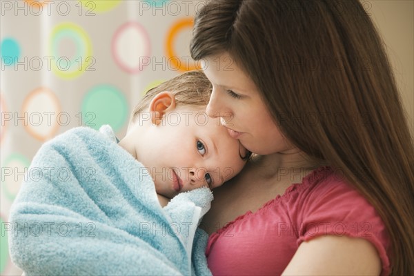 Mother with son (2-3) wrapped in towel. Photo: Mike Kemp