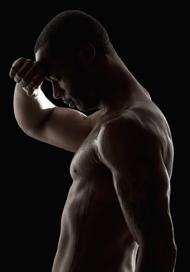 Studio shot of tired shirtless man. Photo : Mike Kemp