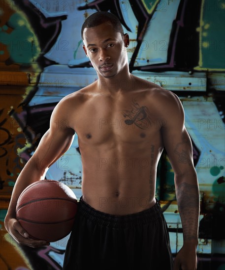 Portrait of young man with basketball. Photo : Mike Kemp