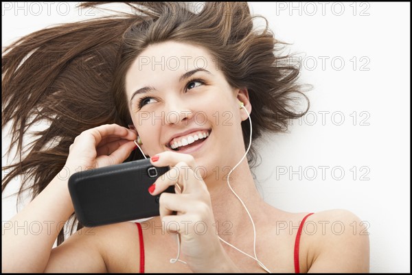 Young woman listening to mp3 player. Photo: Mike Kemp