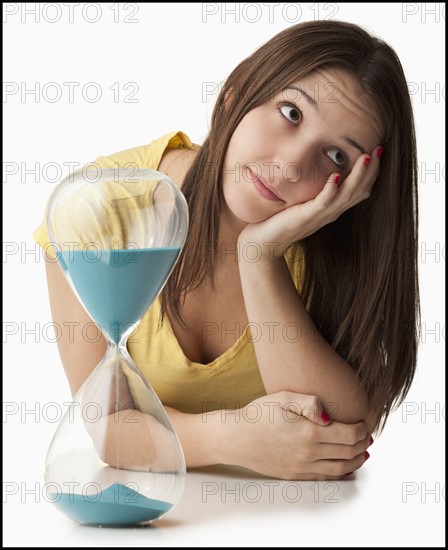 Young woman with hourglass. Photo : Mike Kemp