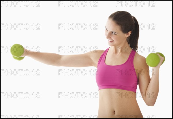 Young woman exercising with hand weights. Photo : Mike Kemp